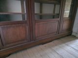 a large wooden cabinet with glass doors in a room