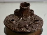 a brown candle holder with a tree stump on top of it