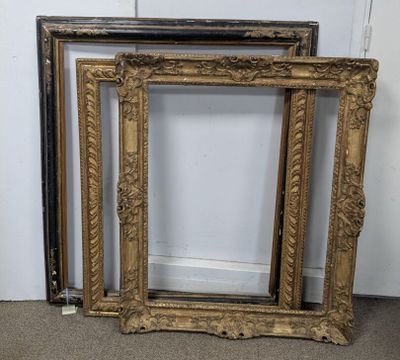 two antique gold picture frames sitting on the floor in front of a white wall