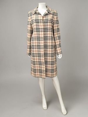 une robe à carreaux beiges et noirs, avec un col et des poignets