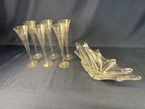 quatre vases en verre transparent et un bol posés sur un tissu bleu