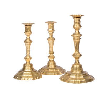 trois bougeoirs dorés sur fond blanc, avec un fond blanc