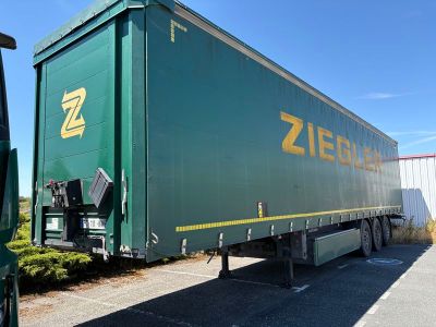 un gros camion vert garé sur un parking