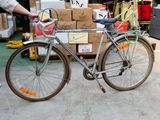 un homme debout à côté d'un vélo garé dans un entrepôt