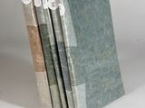 three books are stacked on top of each other on a white surface