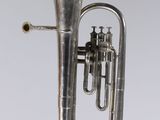 an antique silver plated brass instrument with a bell on a white background