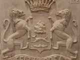 relief représentant un blason orné de deux lions et d'une couronne, sur un bloc de pierre