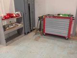 une image d'un garage avec de nombreux outils sur le sol