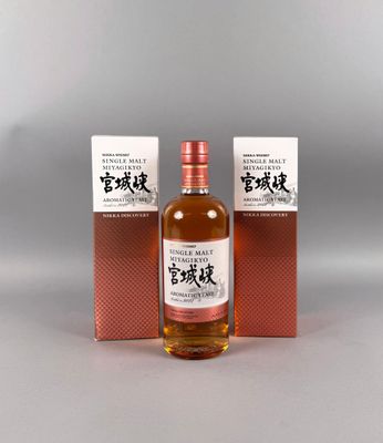 deux bouteilles de whisky posées l'une à côté de l'autre sur une table