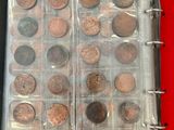 a lot of coins in a binder on a table