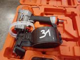 a cordless nail gun in a tool box