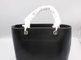 un sac à main noir avec une poignée blanche sur fond blanc
