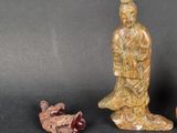 two figurines of a man and a woman sitting next to each other on a table