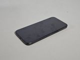 the back of a black cell phone sitting on top of a white table