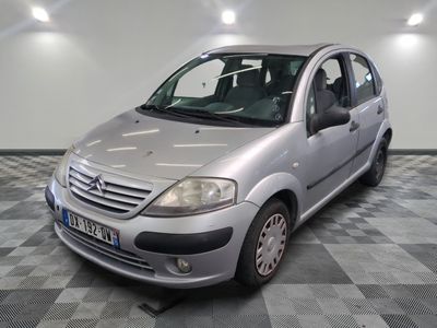 a small silver car parked in a room with checkered floor