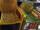 four plastic chairs sitting next to each other in a room