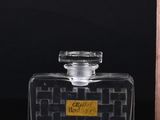 bottles of perfume on a black surface with a box in the background