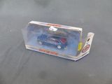 une petite voiture bleue dans une boîte transparente posée sur une table