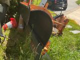 a lawn mower sitting in the grass next to a tree