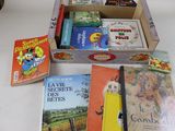 de nombreux livres pour enfants dans une boîte posée sur une table