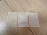 three pieces of fabric with a tag on them sitting on a wooden table