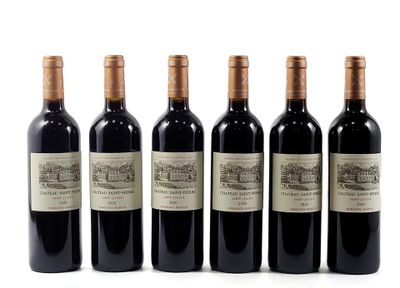 six bottles of wine are lined up on a white surface