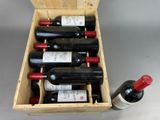 bottles of wine are in a wooden box on a table