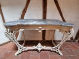 une table au plateau en marbre posée sur un sol en briques