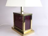 brass and purple glass table lamp with a white shade on a white background