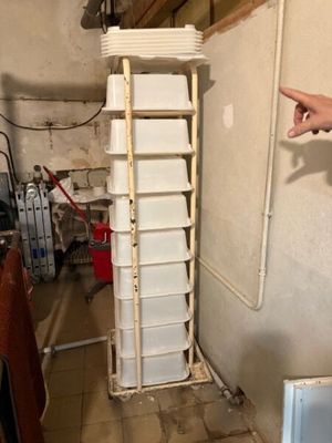 un homme montrant du doigt une pile de conteneurs dans une pièce