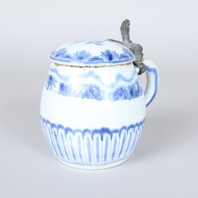 a blue and white cup with a lid and a spoon in it