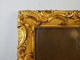 une photo d'un tableau dans un cadre doré accroché au mur