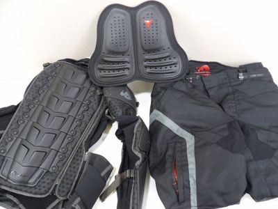 une paire de genouillères et un sac à dos posés sur une surface blanche