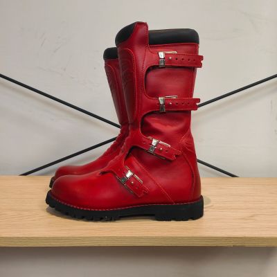 quelqu'un porte une paire de bottes rouges ornées de boucles
