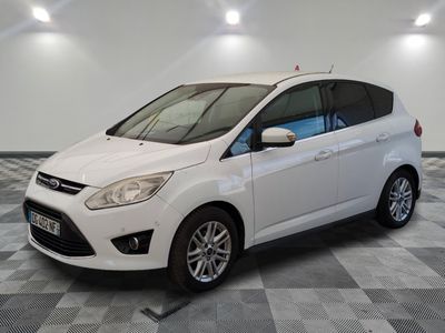 le ford c - max blanc est garé sur un sol en damier