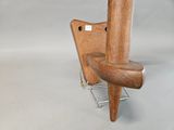 a wooden chair that is sitting on a metal stand