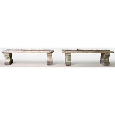 two stone benches sitting next to each other on a white surface
