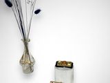 un vase avec des fleurs et un téléphone portable accroché au mur