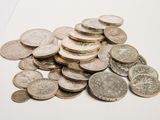 a pile of silver coins on a white surface