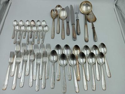 de nombreuses cuillères et couverts en argent posés sur un plateau