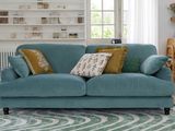 un canapé bleu recouvert de nombreux coussins dans un salon
