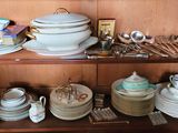 de nombreuses assiettes et bols posés sur une étagère dans un placard