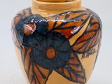 un vase orné d'un papillon sur un fond blanc