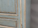 une image représentant une armoire bleue à deux portes et un tiroir