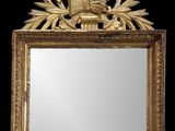 un miroir avec un cadre doré sur lequel est représenté un oiseau