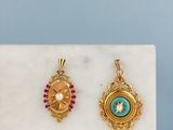deux pendentifs en or et en turquoise posés sur une dalle de marbre