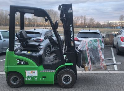 un chariot élévateur vert garé sur un parking