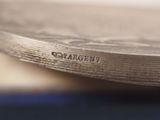 a close up of a silver plate with a name on it