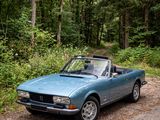 a blue convertible car parked on the side of the road