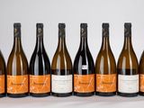 six bouteilles de vin sont alignées sur une table